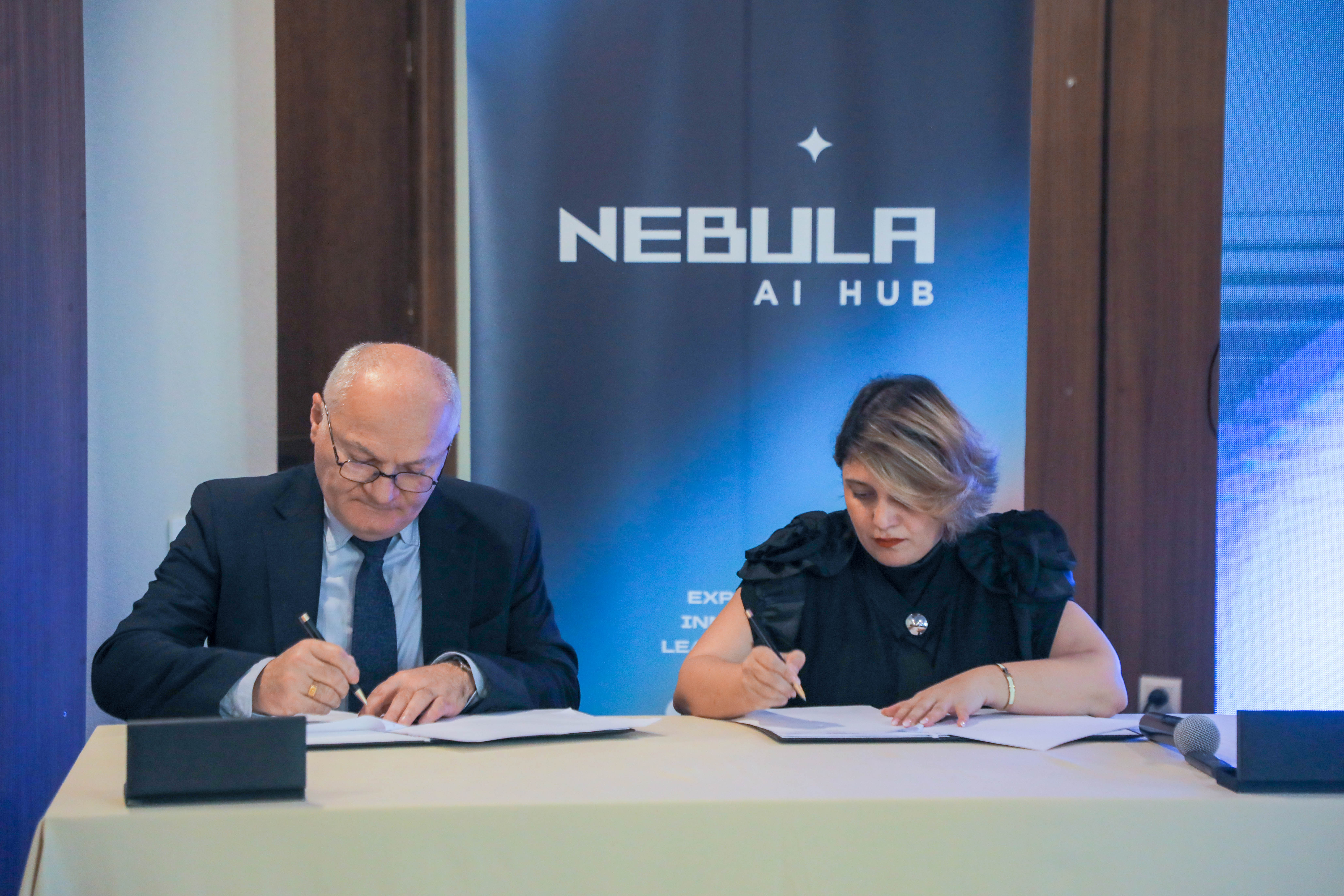 Nebula AI Hub signing ceremony in front of branding backdrop